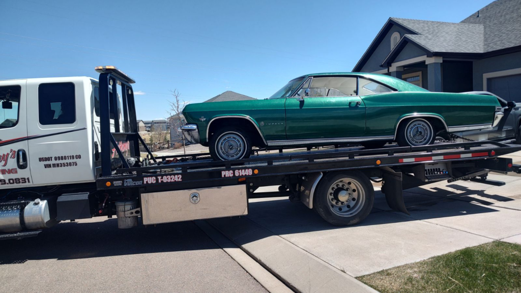 A green car receives prompt service in a home's driveway, ensuring hassle-free holiday road trip planning in the future with Anthony's Towing.
