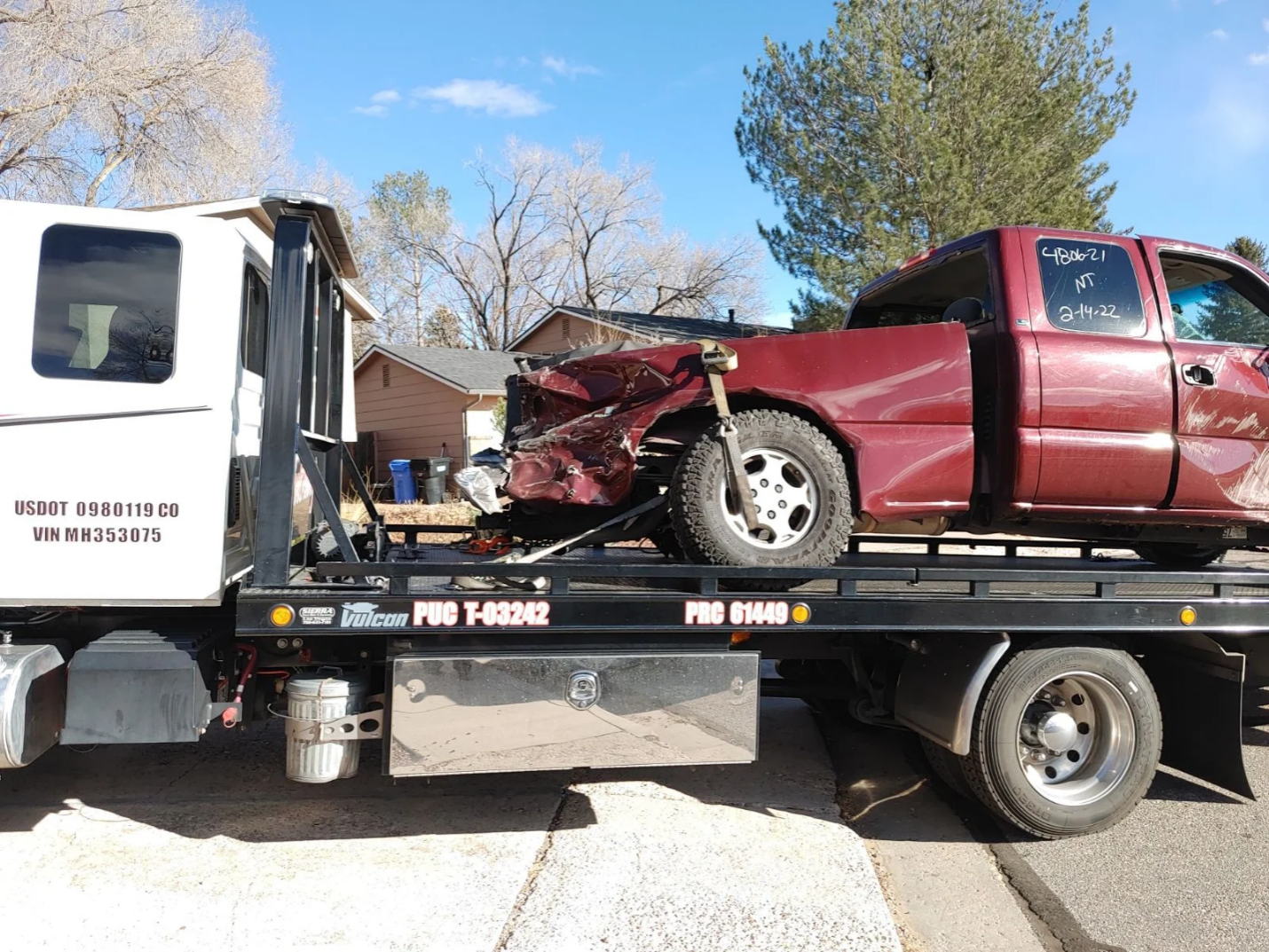A Red Damaged Car on a Tow Truck