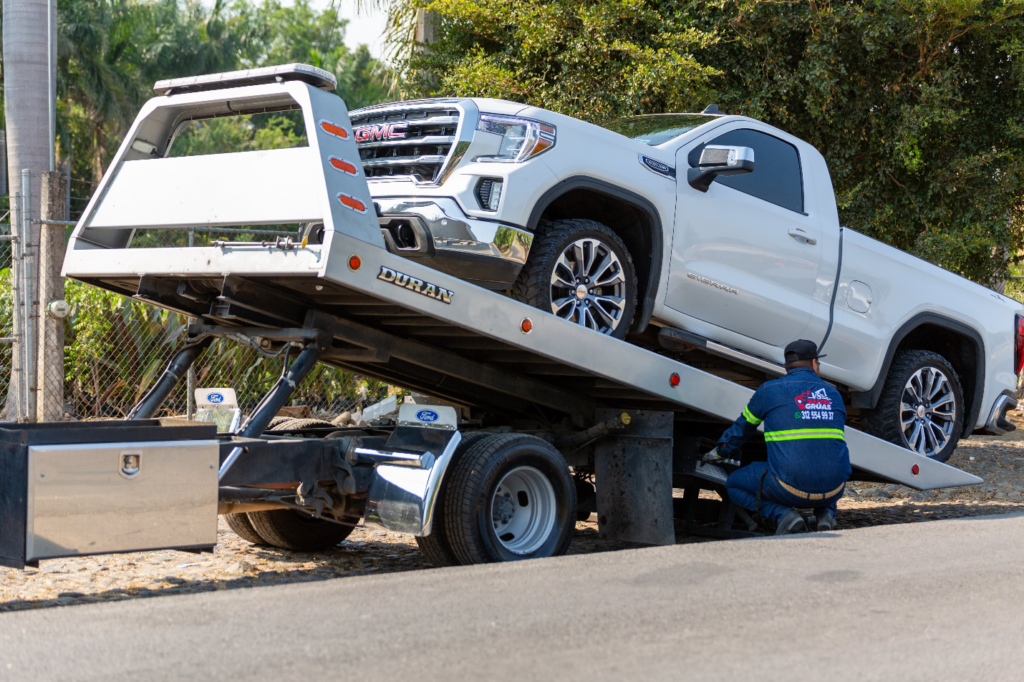  A whitepick-up truck is loaded and secured on a tow truck, ready for transport.