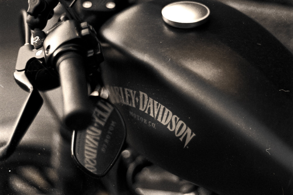  A closeup of a Harley Davidson’s black and silver fuel tank, mirror and handle