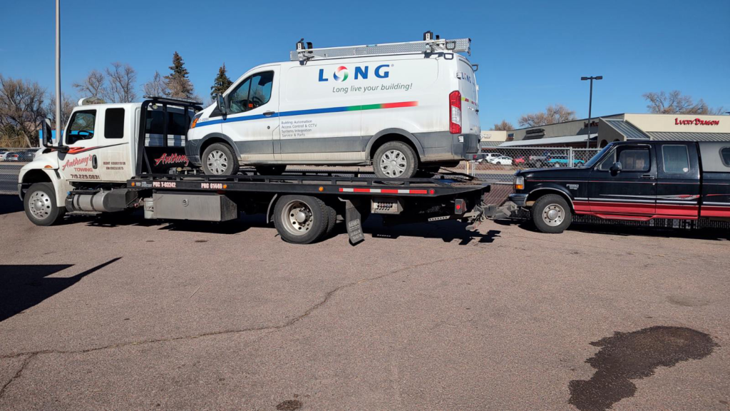 A van branded with LONG securely loaded on an Anthony's Towing tow truck, showcasing the towing expertise for LONG in Colorado Springs.