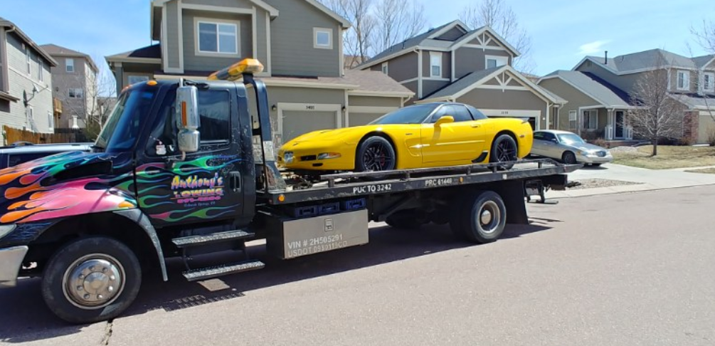 A yellow sports car on a tow truck
